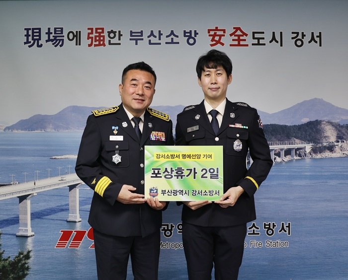 이시현 부산 강서소방서장이 비행기 내에서 응급처치로 승객을 구한 김주신 소방교(사진우측)에게 표창을 수여하고 기념촬영.(사진제공=부산소방재난본부)