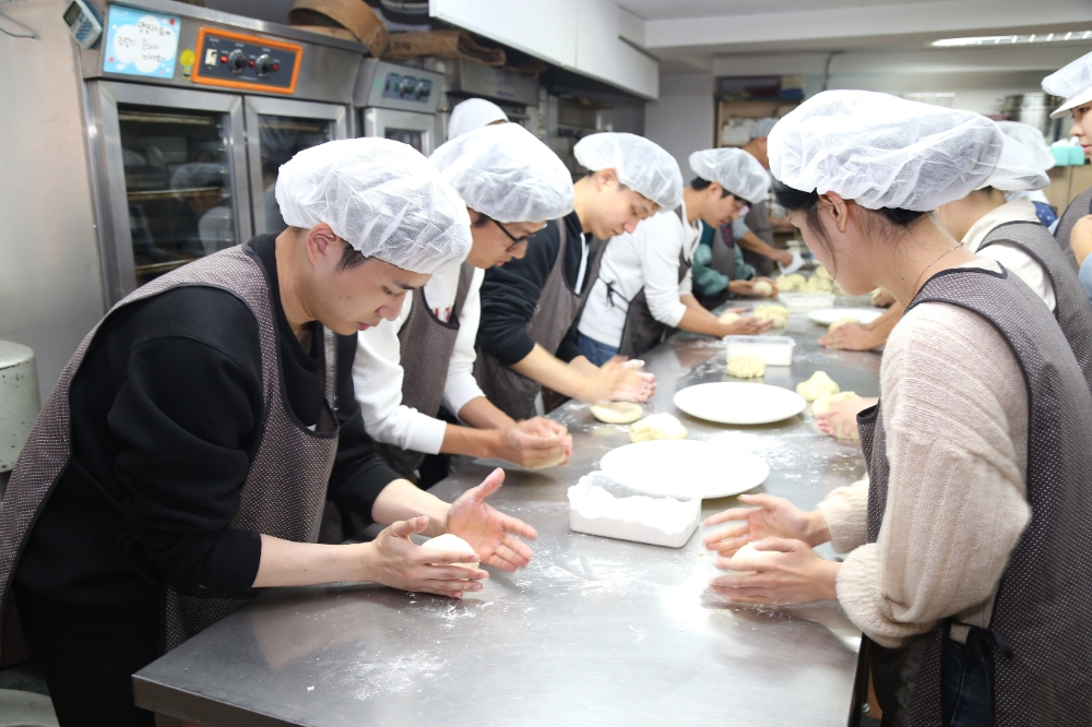 ‘사랑의 빵 만들기’ 봉사활동에 참여한 DL이앤씨 직원들이 밀가루를 반죽하고 있다.(사진=DL이앤씨)