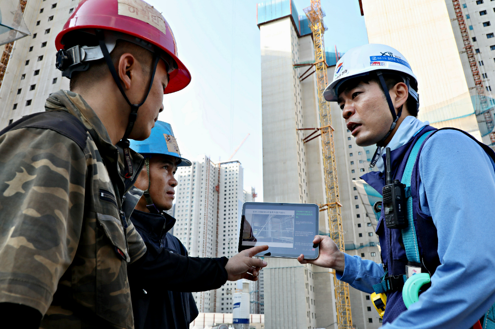 GS건설 아파트 현장에서 ‘자이 보이스’를 활용해 외국인 근로자에게 작업 유의사항을 설명하고 있는 모습.(사진=GS건설)