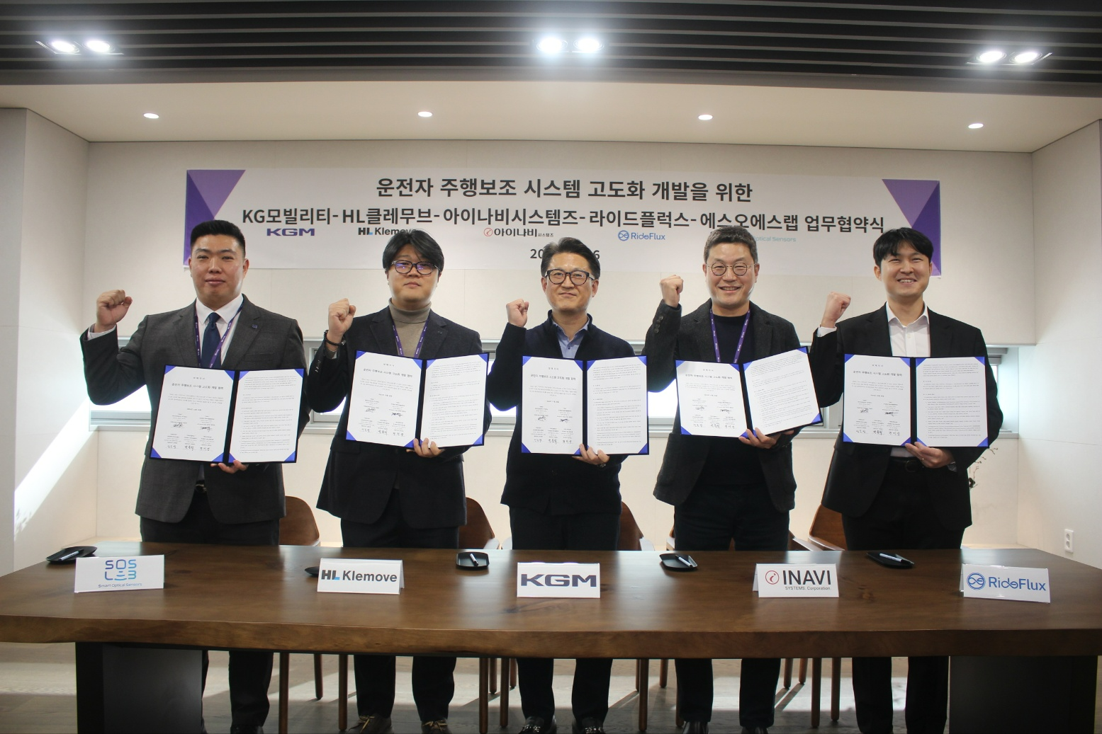 지난 26일 운전자 주행보조 시스템 고도화 개발을 위한 업무협약식에서 이용헌 KGM 상무(왼쪽 세번째), 성득영 아이나비시스템즈 대표이사(왼쪽 두번째)가 협약식 이후 기념촬영하는 모습.(사진=팅크웨어)