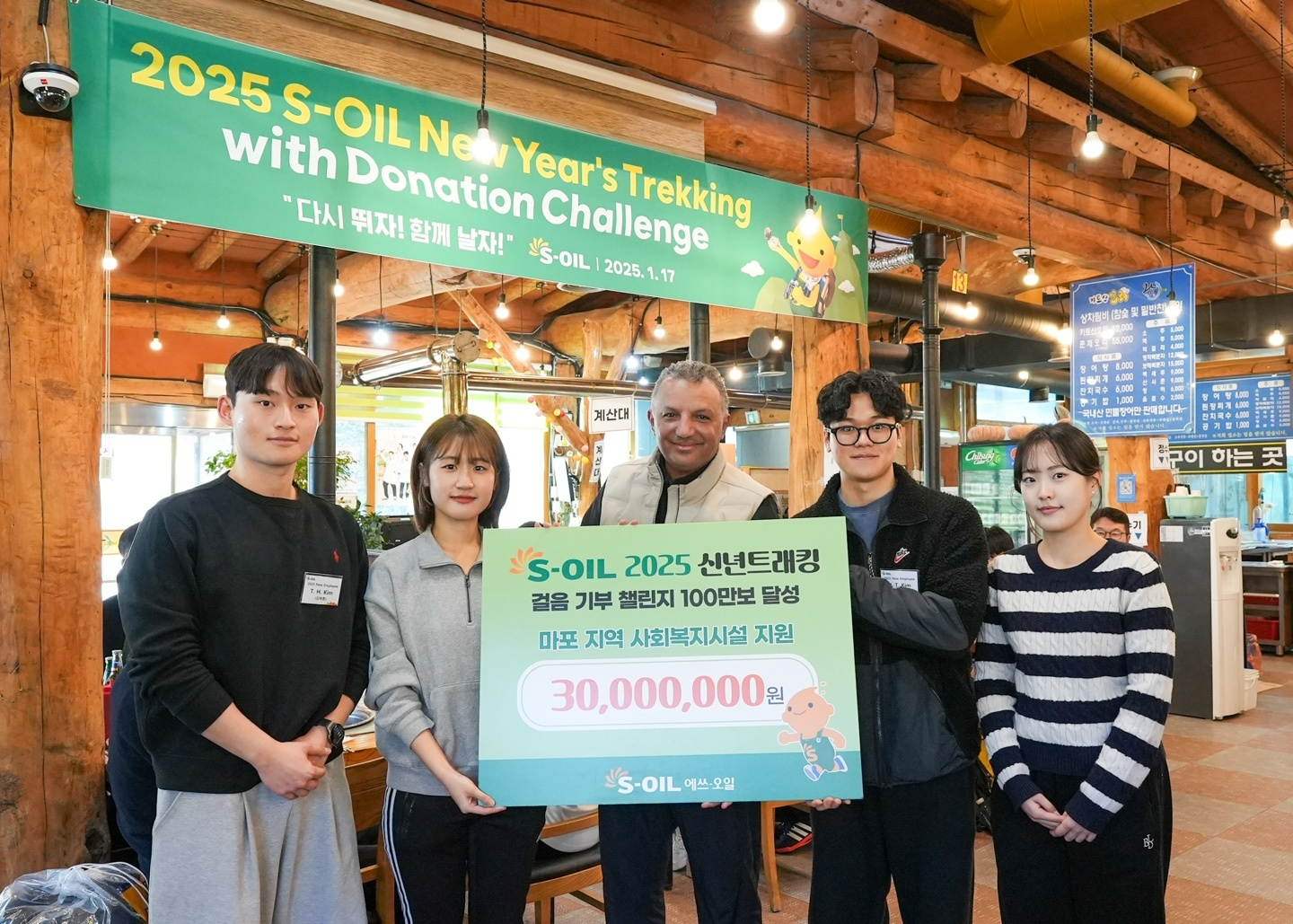 안와르 알 히즈아지 CEO(가운데)와 신입사원들이 17일 신년 트래킹으로 달성한 걸음 기부 챌린지 기념촬영을 하고 있다.(사진=에쓰오일)