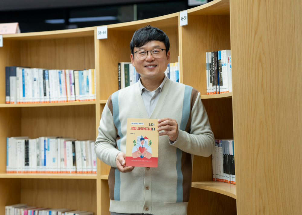 에쓰오일 신영철 사회복지사가 최근 발간한 ‘나는 기업 사회복지사다’ 책을 들고 기념촬영을 하고 있다.(사진=에쓰오일)