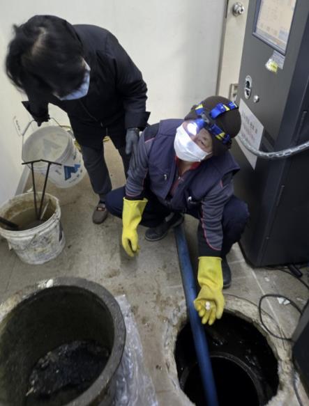 주택 정화조 청소 후 모기 유충구제를 투입하는 모습