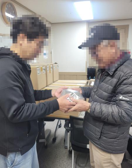 11일 어르신에게 밑반찬 도시락을 전달하고 있다.