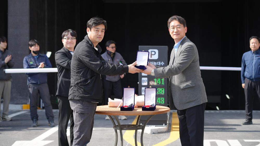 동아건설산업 김서규 건축본부장(상무, 맨 앞 오른쪽)이 지난달 말 경기 평택시 통복동(577번지 일원) ‘평택역 경남아너스빌 디아트’에서 진행된 입주 기념 점등식에 앞서 입주예정자협의회 이광현 대표로부터 감사패를 건네받으며 기념촬영을 하고 있다.(사진=SM그룹)