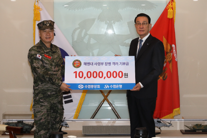 노동진 수협중앙회장(오른쪽)이 26일, 해병대 사령부에서 장병 맞춤형 수산물 요리를 제공하는 수산물 데이를 연 뒤 격려금을 전달하고 있다. (사진=수협중앙회)