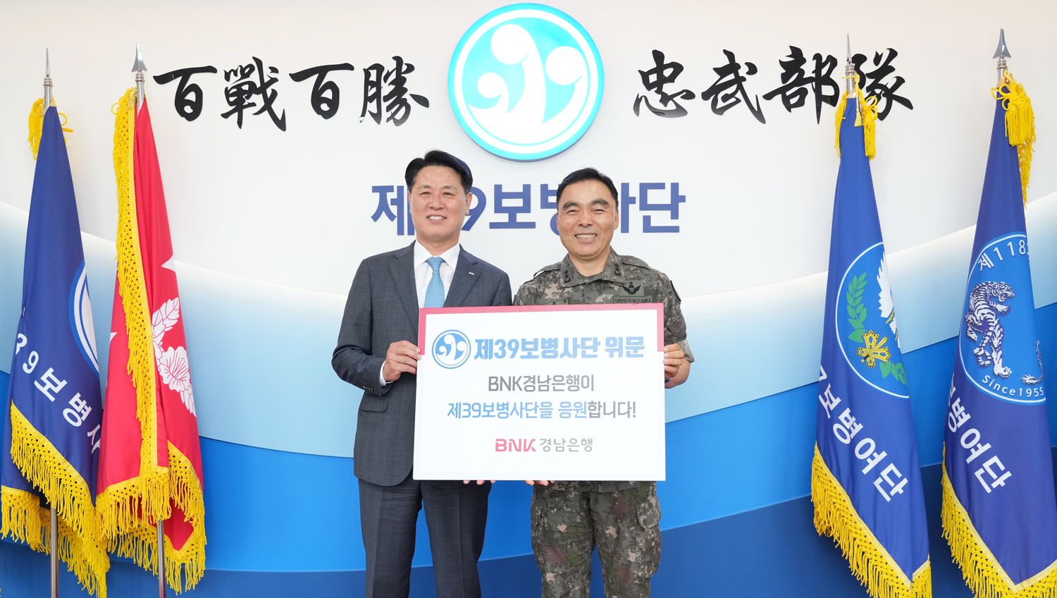 BNK경남은행 김태한 은행장(사진 왼쪽)이 제39보병사단 김종묵 사단장에게 위문금을 전달하고 있다. 사진=BNK경남은행