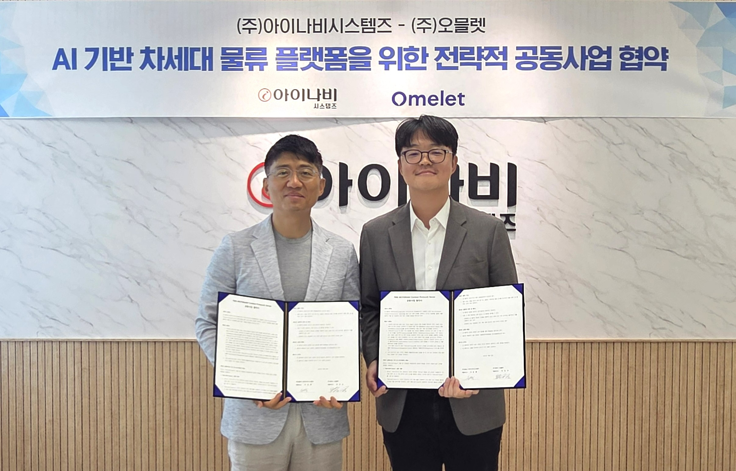 (좌) 아이나비시스템즈 이은복 대표이사, (우) 오믈렛 박진규 대표이사.(사진=팅크웨어)