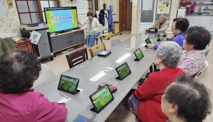 목화경로당에서 어르신들이 정보통신기술(ICT)을 활용한 치매 예방 인지훈련 교육을 수강하고 있다