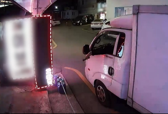 리모컨으로 노래방 간판을 오작동하게 만들고 있는 모습.(제공=부산경찰청)