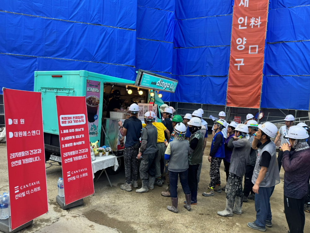 ㈜대원, (주)대원에스앤디 가 인천 ‘원당 칸타빌 더 스위트’ 현장에서 진행한 ‘이동형 건강증진 캠페인’에서 근로자들이 냉음료와 간식을 받고 있다.(사진=대원)