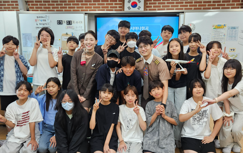 3일(수) 서울공진초등학교에서 열린 항공진로 직업특강에서 (왼쪽부터)이민정 부사무장, 이동준 부기장이 학생들과 기념촬영을 하고 있다.(사진=아시아나항공)