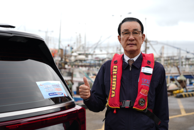 노동진 수협중앙회장이 26일, 제주항에서 '도로에는 안전벨트, 바다에는 구명조끼'라는 슬로건이 적힌 홍보스티커가 부착된 차량과 함께 챌린지에 참여하고 있다. 한편, 이번 챌린지는 차량 또는 어선에 구명조끼 착용 의무화 관련 홍보스티커를 부착 후 인증사진을 촬영하는 방식으로 진행되고 있다.(사진=수협중앙회)