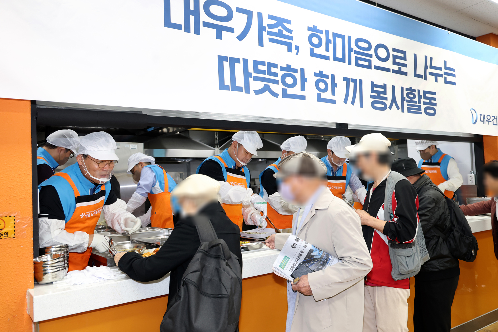 대우건설 김보현 대표이사(왼쪽)와 심상철 노동조합 위원장(오른쪽)이 무료 급식 봉사활동에 참여하고 있다.(사진=대우건설)