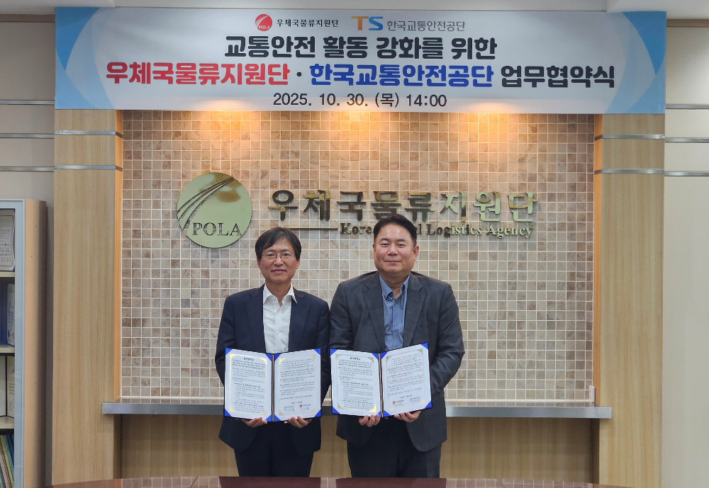 한국교통안전공단 황성재 교통안전정책실장(사진 왼쪽)과 우체국물류지원단 이지훈 소포사업처장이 업무협약 후 사진을 찍고 있는 모습.(사진=TS)