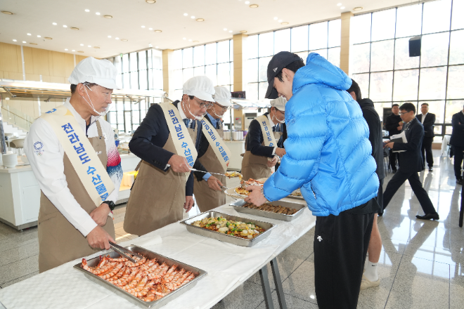 노동진 수협중앙회장(왼쪽 두번째)이 12일, 충북 국가대표선수촌에서 열린 수산물 전달 행사에서 내년 동계올림픽 출전을 앞둔 선수단에게 수산물 특식을 직접 배식하며 선수들을 격려하고 있다.(사진=수협중앙회)