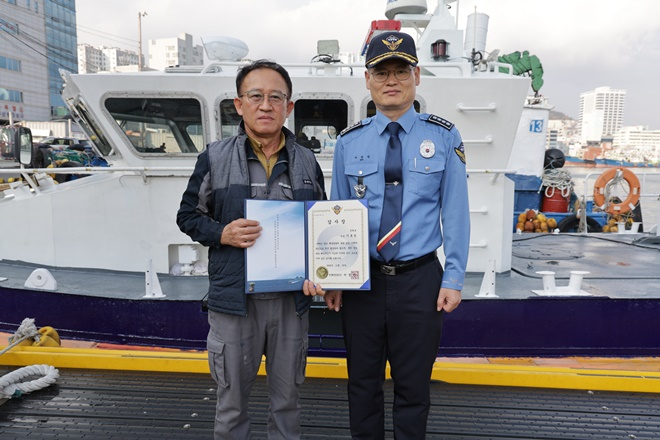 서정원 서장이 이호성 선장에게 감사장을 전달하고 기념촬영.(사진제공=부산해양경찰서)