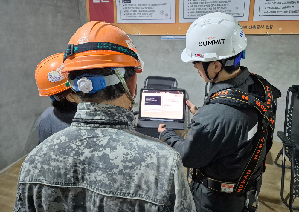호반건설 직원이 건설 현장에서 AI 동시번역 플랫폼 ‘호반커넥트’를 활용해 근로자들과 대화하고 있다.(사진=호반건설)